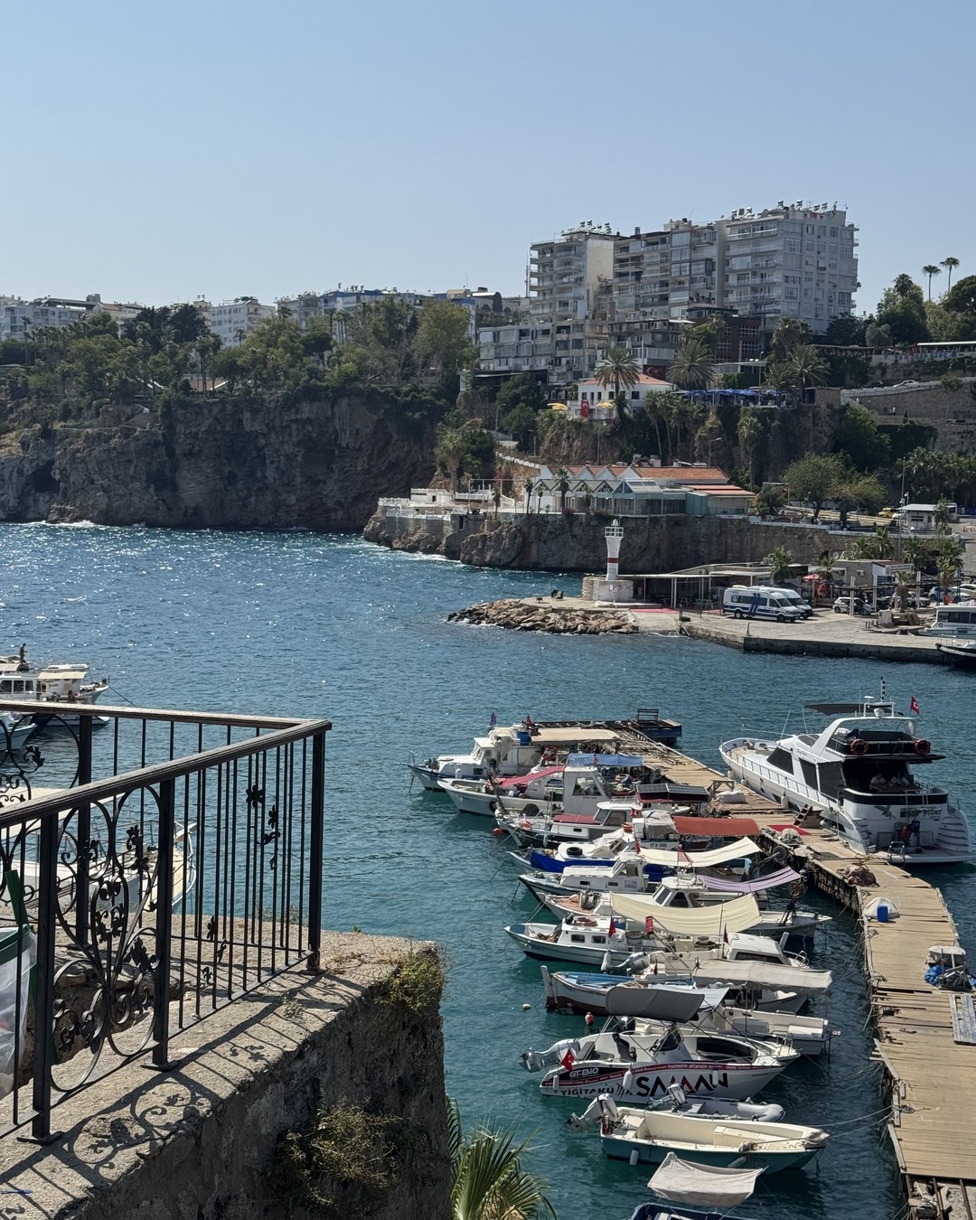 Fishing boats moored in the old harbour at Antalya below the stone walls of the old town