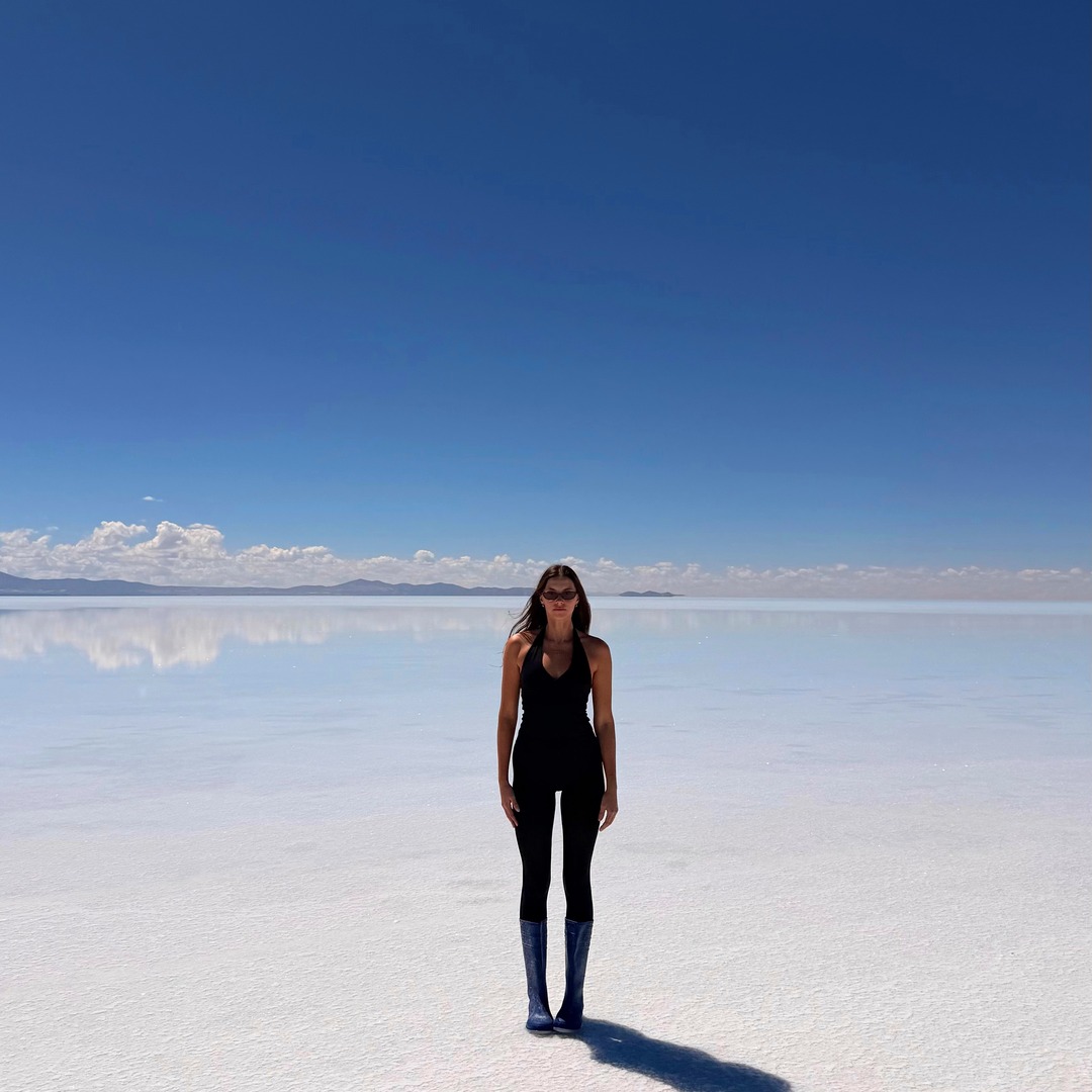 Ellen standing on the bright white Uyuni salt flats in daylight