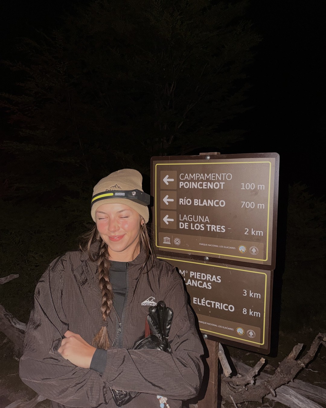 Ellen in a beanie and head torch at the trail sign 2 km from Laguna de los Tres