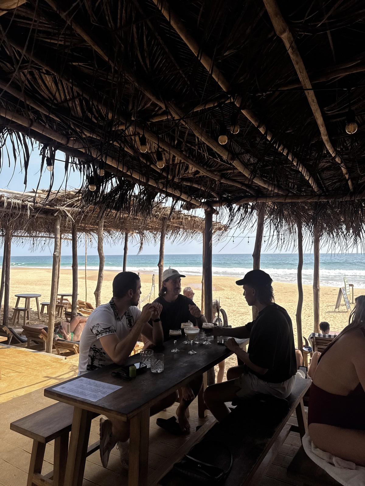 Beachside tables beneath the thatched roof at Amaroo in Hikkaduwa, Sri Lanka