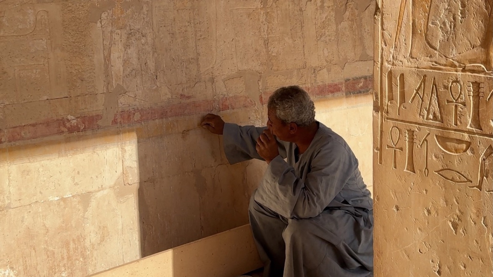An Egyptologist explaining original carvings inside the Temple of Hatshepsut on Luxor's West Bank