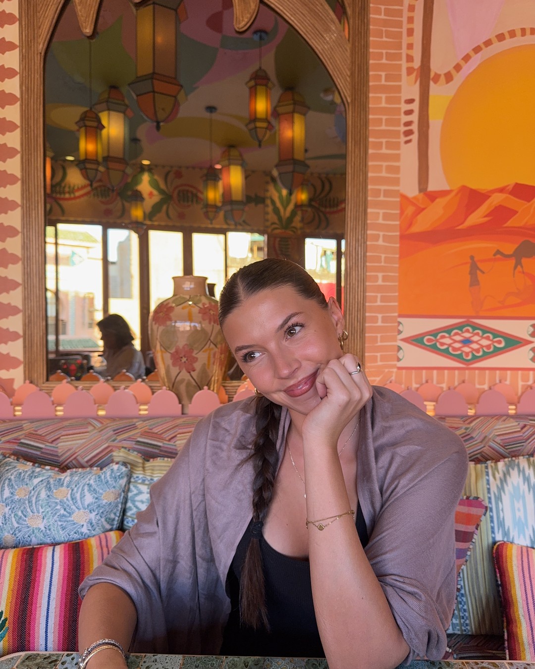 Ellen sitting in a brightly painted cafe with lanterns and patterned cushions in Marrakech, Morocco