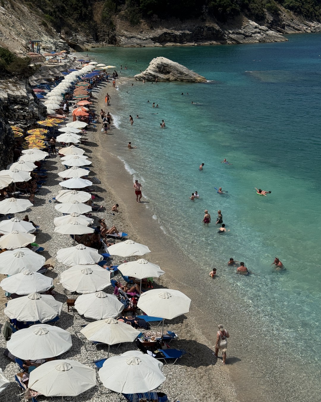 Beach umbrellas beside turquoise water at Ksamil, Albania