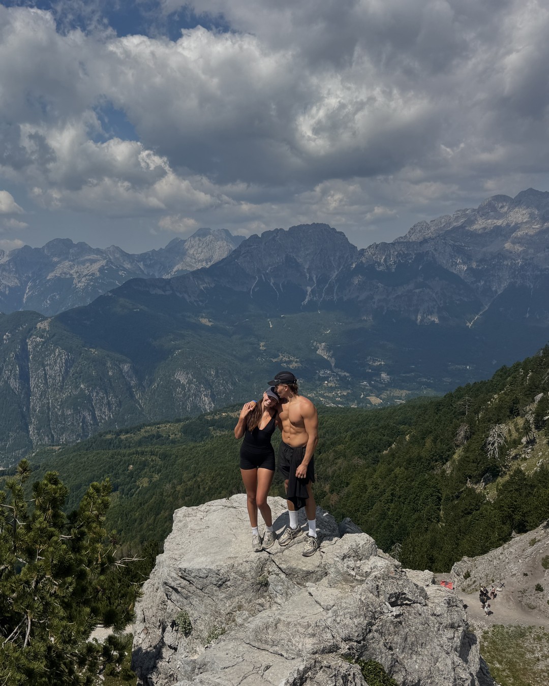 Hikers on a rocky outcrop in the Albanian Alps on the Valbonë to Theth trail