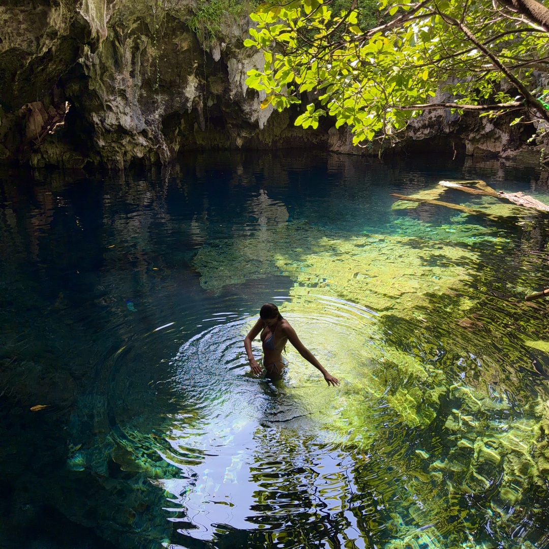Ellen swimming in clear sunlit water at Maalum Cave in Paje, Zanzibar